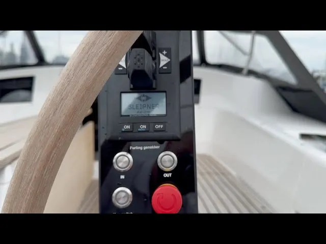 A still from Sleipner's X-Yachts video: a sailboat's helm pedestal with the Sleipner thruster panel beside the wheel.